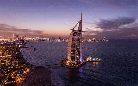 Aerial View Of Burj Al Arab Luxury Hotel At Sunset With Cityscape