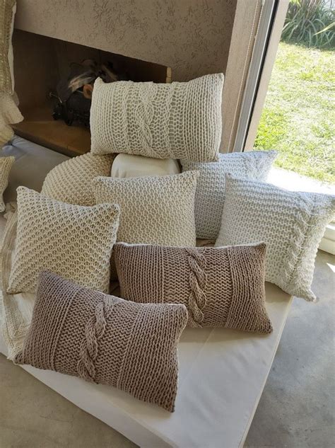 Several Pillows On A Bed With A Fireplace In The Background