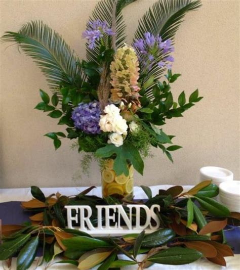 Flowers And Greenery Are Arranged In A Vase On A Table With The Words Friends