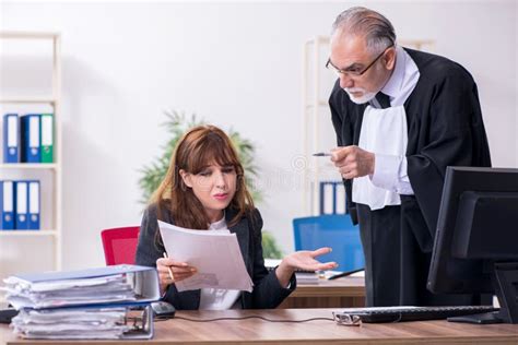 Old Male Judge And His Young Secretary In The Office Stock Photo