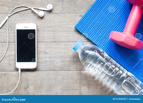 Flat Lay Of Smartphone With Yoga Mat Dumbbell And Bottle Stock Photo