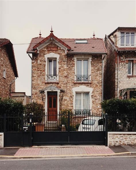 An Old Brick House With A Black Gate