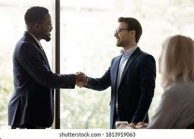 Smiling Businessman Handshake Male Colleague Congratulate Stock Photo