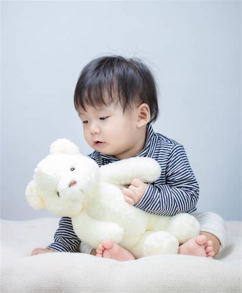 Premium Photo | Cute baby playing teddy bear