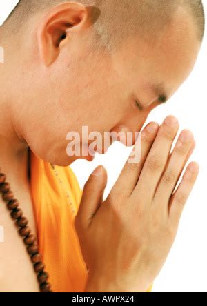 Side View Of Buddhist Monk With Shaved Head Wearing Black And Yellow