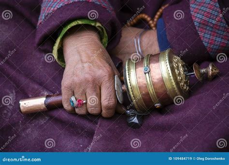 Old Hands Of A Tibetan Woman Holding Prayer Buddhist Wheel At A Hemis