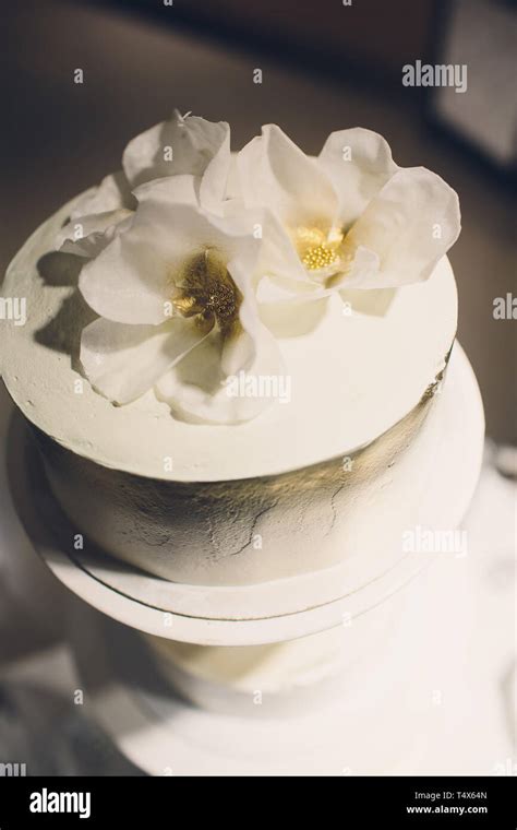 Three Tiered White Wedding Cake Decorated With Flowers From Mastic On A