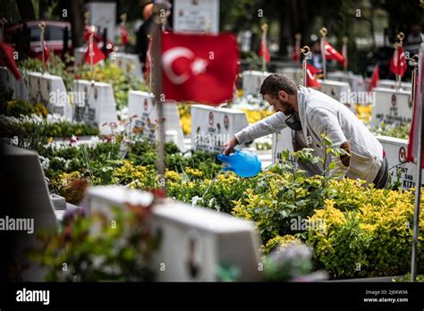 A Man Is Seen Watering The Flowers On A Martyr S Grave The Families Of