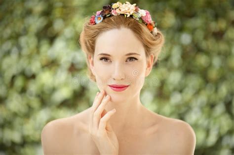 La Mujer Joven Hermosa Con Las Flores Enrruella En Pelo Foto De Archivo