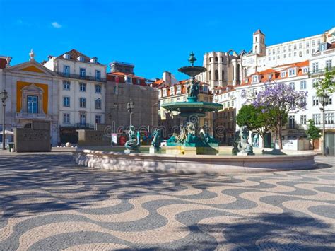 Rossio Square In Lisbon In Portugal With Purple Blooming Jacaranda