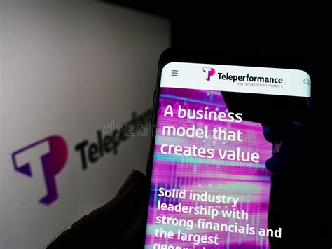 Person Holding Smartphone With Logo Of French Company Teleperformance