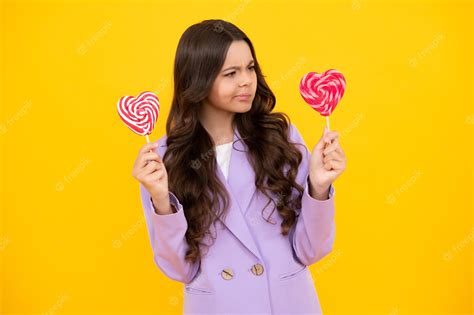 Premium Photo | Funny child with lollipop over yellow isolated ...