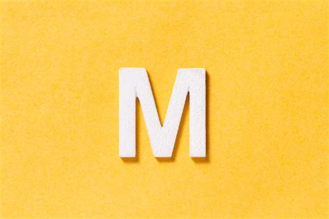 Premium Photo | Letter M of the alphabet isolated on yellow background ...