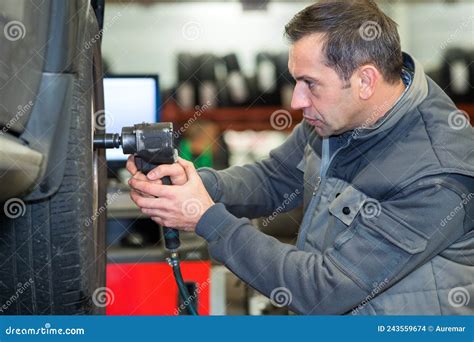 A Man Removing A Tire From The Rim After Using A Tire Bead Breaker At A