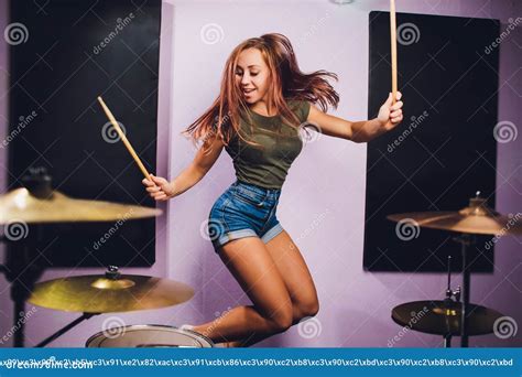 Photograph Of A Female Drummer Playing A Drum Set On Stage Stock Image