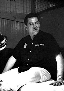 A Black And White Photo Of A Man Sitting On A Bed