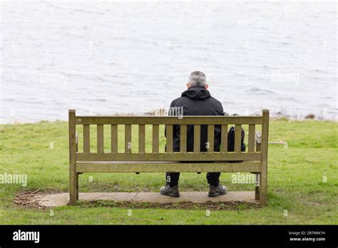 Person sitting alone on bench hi-res stock photography and images - Alamy