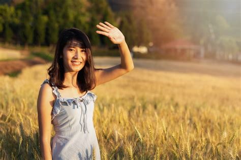 Hermosa y feliz mujer asiática disfrutando de la vida en el campo de