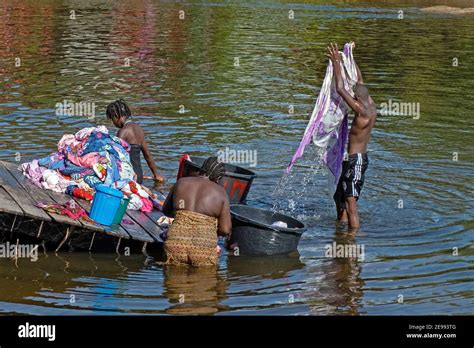 Afro-Surinamese family washing clothes in the Suriname River near ...