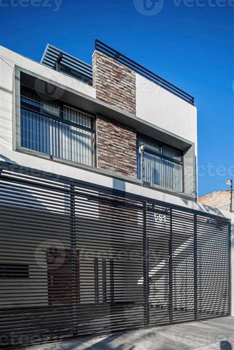 Facade Of A Modern House With Stone Staple That Wraps The Windows