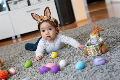 Cute Baby Girl Crawling Around The Easter Eggs On Floor In The Living