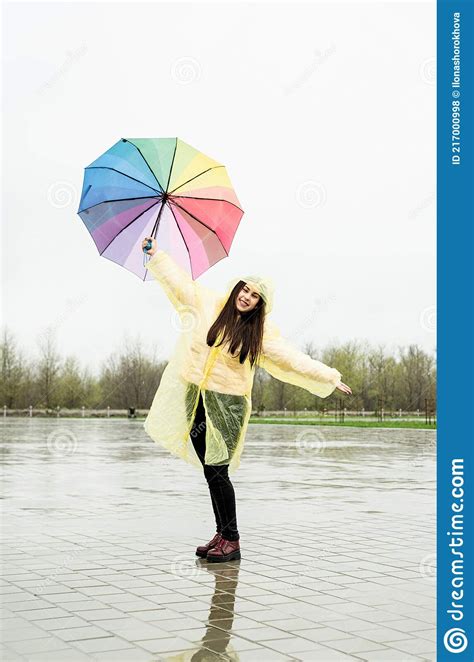 Beautiful Brunette Woman Holding Colorful Umbrella Out In The Rain