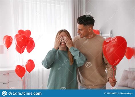 Man Surprising His Girlfriend With Heart Shaped Balloon Indoors