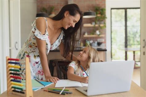 Una Madre Ayudando A Su Hija Con Los Deberes En Un Hogar C Modo Foto