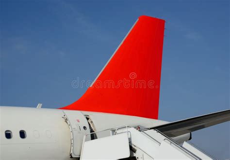 Avión Con La Cola Roja Escalerilla De Embarque Cielo Azul éxito Imagen