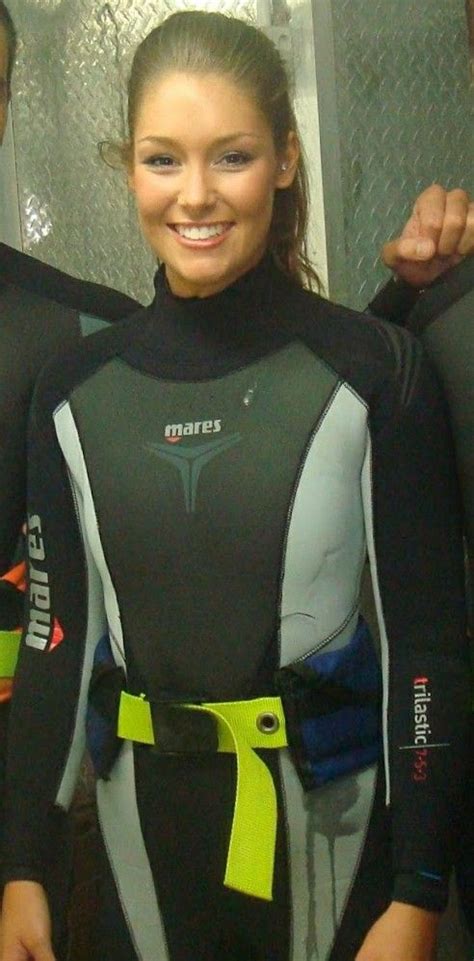 Two Women In Wetsuits Standing Next To Each Other