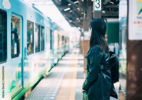 駅のホームで電車を待つ女性 фотография Stock Adobe Stock