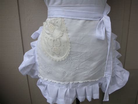 A White Apron With Ruffles And Lace On It