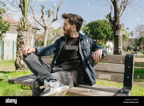 Handsome Young Man With Beard Wearing Blue Jeans Sitting Relaxed On A