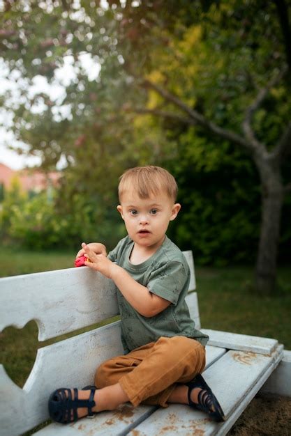 Enfant Plein Coup Sur Banc Jouant Photo Gratuite