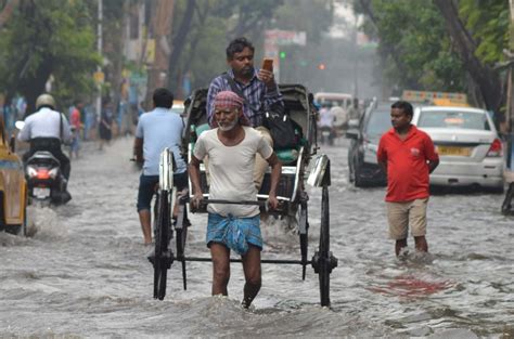 Rickshaw Puller Wades Through Water Logged Street In Kolkata