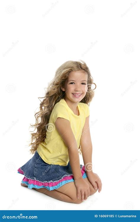 Verticale De Sourire De Petite Fille Blonde Sur Ses Genoux Image Stock