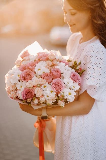 Una Mujer Feliz Con Un Vestido Blanco Al Atardecer Con Un Ramo De