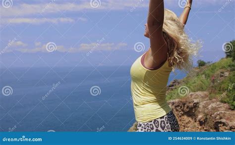 Free Woman Standing On The Edge Of The Cliff And Enjoying The Sea View