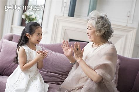 Happy Grandmother And Granddaughter Playing Clapping Game