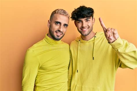 Homosexual Gay Couple Standing Together Wearing Yellow Clothes Showing