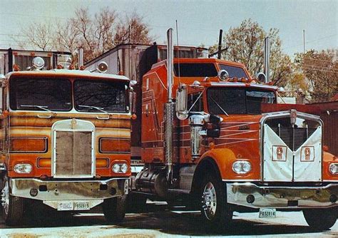 Two Semi Trucks Are Parked Next To Each Other