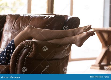 Long Beautiful Legs Of Young Caucasian Woman Relaxing On Couch Stock