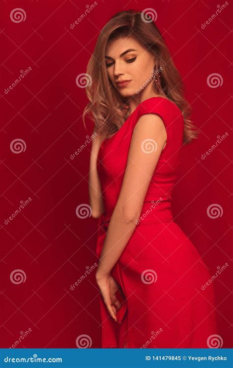 Mulher Loura Que Levanta No Vestido Vermelho No Fundo Vermelho Imagem