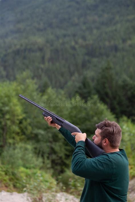 Un Hombre Sostiene Una Escopeta En La Parte Baja Listo Para Disparar A