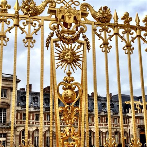 Gates At Palace Of Versailles With Sun King Symbol Of Louis Xiv