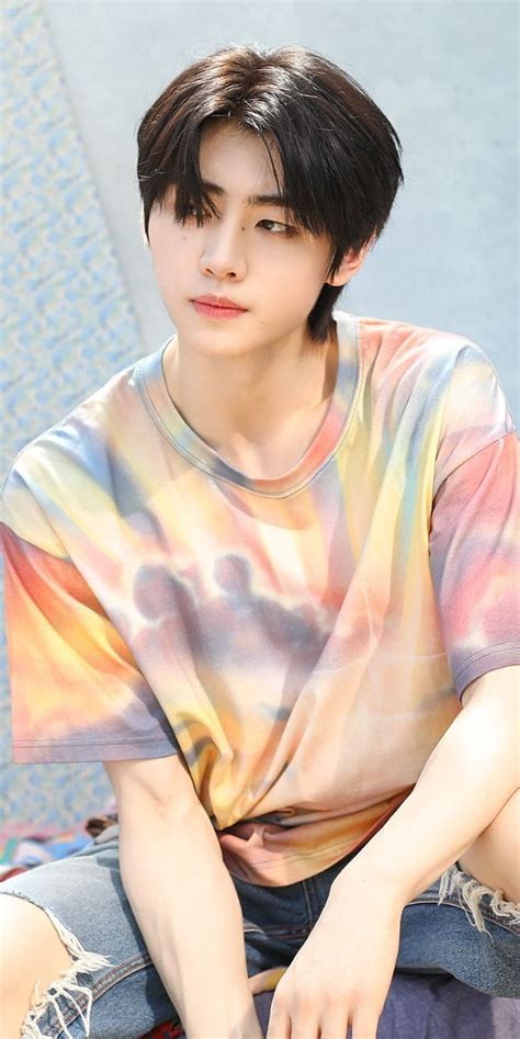 A Young Man Sitting On The Ground Wearing A Tie Dye Shirt