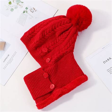 A Red Knitted Hat And Scarf On Top Of A Table