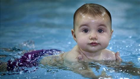 Cute Baby Is Swimming On Body Of Water Wearing Purple Shorts In A Blur ...