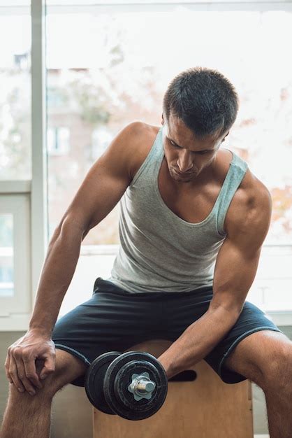 Hombre Musculoso Haciendo Ejercicio Con Pesas Foto Gratis