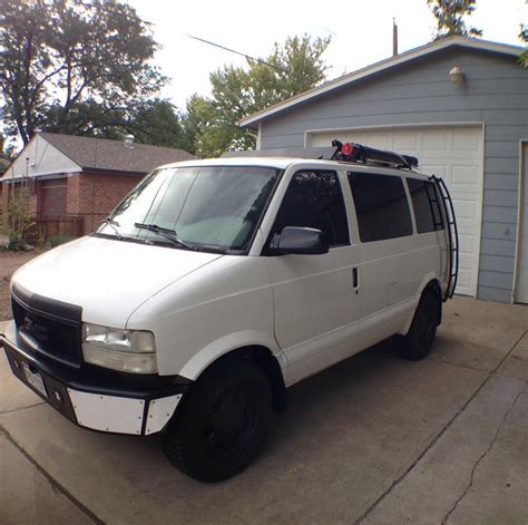 A White Van Parked In Front Of A Garage